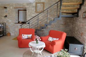 two red chairs and a table in a living room at Casa Le Finide in Bale