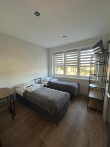 two beds in a room with a window and a ladder at MILITARY Guest Inn in Drawsko Pomorskie