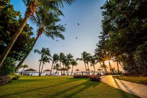 a view of a lawn with palm trees and the ocean at FunxVivid Seaview 2BR 2CP near SG CIQ KSL ZooJB Free Netflix WiFI in Johor Bahru
