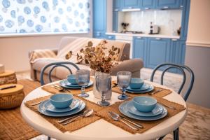 a dining room table with plates and glasses on it at GreenTeam Apartments in Râmnicu Vâlcea
