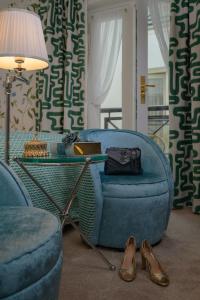 a living room with a blue couch and a table and shoes at Hotel Estheréa in Amsterdam