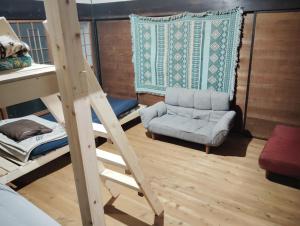 a room with a ladder and a chair and a bed at Hostel 53 in Tuyama