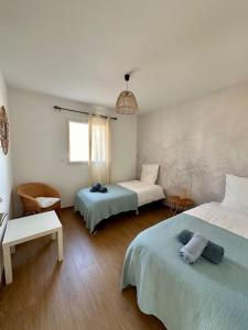 een slaapkamer met twee bedden en een tafel en een stoel bij Port-Manech', Maison avec piscine - Plages à pied in Kermen