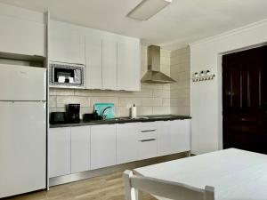a kitchen with white cabinets and a white refrigerator at Apartamento Luna by Vulcano Homes in Nazaret