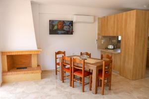 a kitchen with a table and chairs and a fireplace at ALTAVILLAS maisonettes in Kakí Vígla
