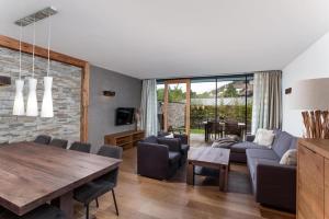 a living room with a wooden table and a couch at Residenz Wildkogelbahnen Top 4 in Neukirchen am Großvenediger