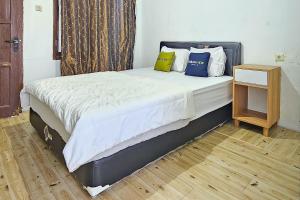 a bed with three pillows on it in a room at Urbanview Orchid Guest House in Ciater +15 photos