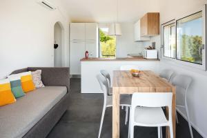 una cucina e un soggiorno con un tavolo e un divano di Sardegna è - Beach Apartments a Olbia Altre 14 foto