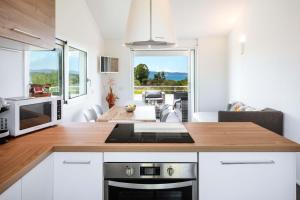una cucina con mobili bianchi e un piano di lavoro di Sardegna è - Beach Apartments a Olbia