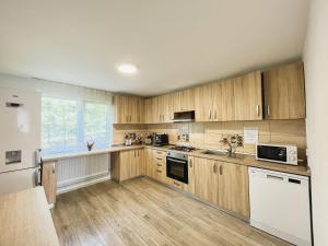 a kitchen with wooden cabinets and a white refrigerator at Casa Dia Belis in Beliş +25 photos