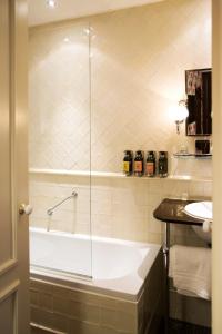 a bathroom with a bath tub and a sink at Hotel Estheréa in Amsterdam