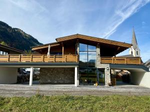 ein Gebäude mit Balkon und einer Kirche in der Unterkunft Alprocks Alvaresort in Bichlbach