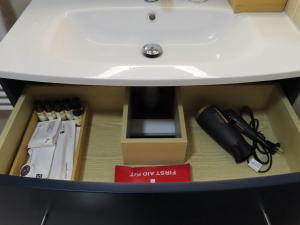 a drawer under a sink with a box under it at Chambre avec grand lit et salle de bain privative pour 2 personnes in Bondy