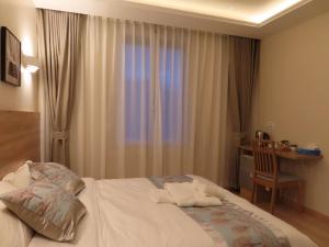 a bedroom with a bed with a desk and a window at Chambre avec grand lit et salle de bain privative pour 2 personnes in Bondy