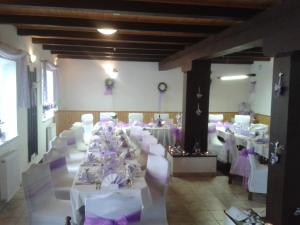 a banquet hall with white tables and white chairs at Penzion Hajský mlýn in Nebanice