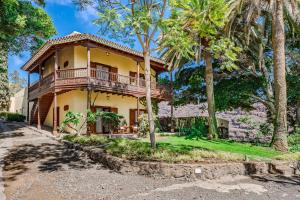 dom z balkonem i palmami w obiekcie Villas la Gomera w mieście Alajeró