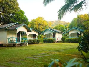 una fila de cabañas en un parque con un patio de césped en Impian Inn, en Tioman Island