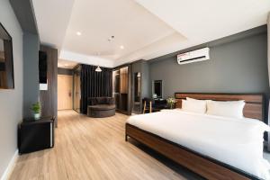 a bedroom with a large white bed and a desk at The Hotel Nicecy in Ho Chi Minh City