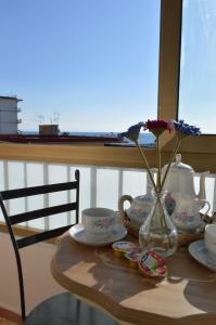 una mesa con un jarrón con flores en una ventana en B&B Al Golfo, en Salerno