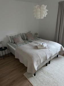 a white bedroom with a bed with a towel on it at Arctic Jaakko Suite in Rovaniemi