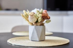 a vase with flowers in it sitting on a table at Apartamente by R S in Năvodari