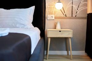 a bedroom with a bed and a nightstand with a lamp at Apartamente by R S in Năvodari