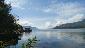 a view of a lake with a house on the shore at Zoé’s Paradise Waterfront Hotel in Tuktuk Siadong
