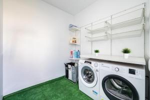 a laundry room with a washing machine and green carpet at Rooms Canteras Boutique Hostal in Las Palmas de Gran Canaria