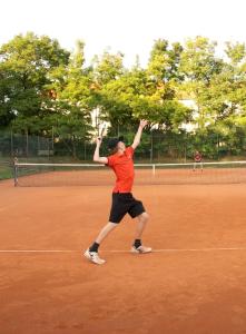 Ein Mann, der einen Tennisball auf einem Tennisplatz serviert. in der Unterkunft Hotel Schloss Mailberg in Mailberg