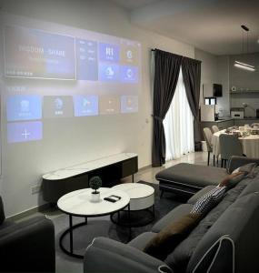 una sala de estar con sofás y una pantalla grande en Bukit Indah Double Storey House nearby AEON - Legoland - Tuas - 9Pax, en Johor Bahru