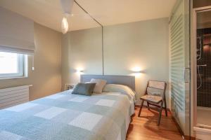 a bedroom with a bed and a chair in it at Sir William, duplex appartement Knokke in Knokke-Heist