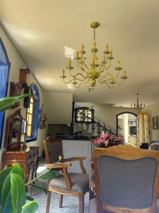 a living room with a chandelier and a table and chairs at Pousada Vale do Queijo Serro in Sêrro +19 photos
