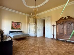 a large bedroom with a bed and a chandelier at Schloss Welsdorf in Fürstenfeld