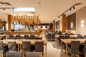 a dining room with wooden tables and chairs at Akces Medical Fit & Spa in Dźwirzyno