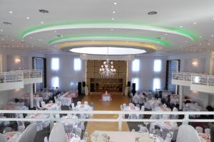 a banquet hall with tables and chairs and a chandelier at Ioannou Resort in Ptolemaida