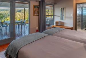 a bedroom with a bed and a balcony with a table at Riverview House Sedgefield in Sedgefield