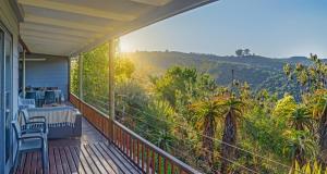 a balcony with a table and chairs and a view of the mountains at Riverview House Sedgefield in Sedgefield