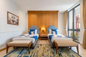 Кровать или кровати в номере The Astor - All Suites Hotel Candolim Goa