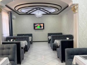 Un comedor con mesas y sillas y un televisor. en Karakalpak Palace Hotel, en Nukus