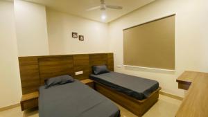 Habitación con 2 camas y una pantalla grande. en C Suites - Adelaide, en Bangalore