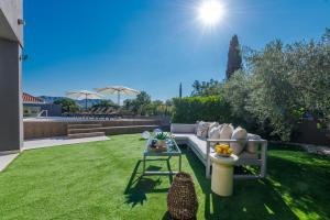a garden with a couch and a table in the grass at Villa Jelena in Mlini