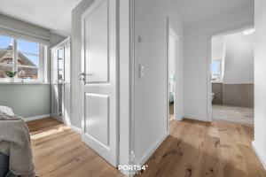 a room with white walls and a sliding door at Reetdachkate Reethüüs Kappeln in Kappeln +28 photos