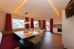 cocina y comedor con mesa y cortinas rojas en Apart Josef, en Ladis