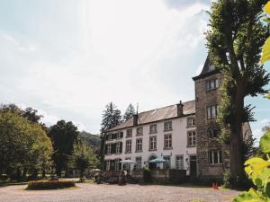 un grande edificio con un albero di fronte di Apartment in Aywaille near Château de Dieupart ad Aywaille