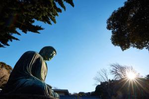a statue of a man with the sun in the background at KAMAKURA Hotel in Kamakura