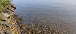 une grande masse d'eau avec des rochers dans l'eau dans l'établissement Traditional Finnish lakeside off-grid cabin, à Joensuu 35 autres photos
