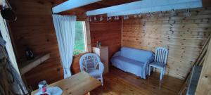 une chambre avec une table et deux chaises dans une cabine dans l'établissement Traditional Finnish lakeside off-grid cabin, à Joensuu