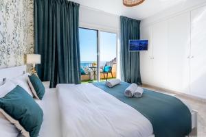 een slaapkamer met een groot bed met een groot raam bij Eden Luxury Home in Puerto de Santiago +36 foto's