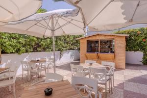 Un restaurante con mesas, sillas y sombrillas. en Moon Dreams Roquetas, en Roquetas de Mar