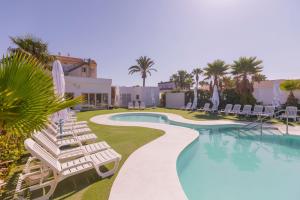 Una piscina con tumbonas y un resort. en Moon Dreams Roquetas, en Roquetas de Mar